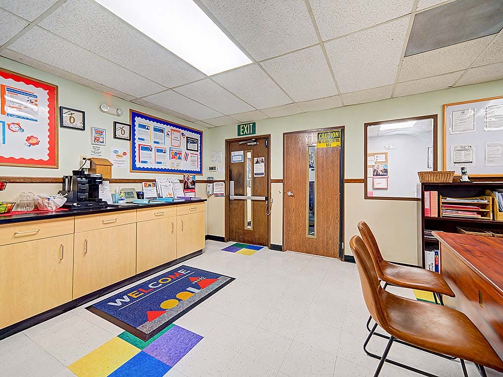 Lobby area with bulletin boards, counter, two doors, and a welcome mat