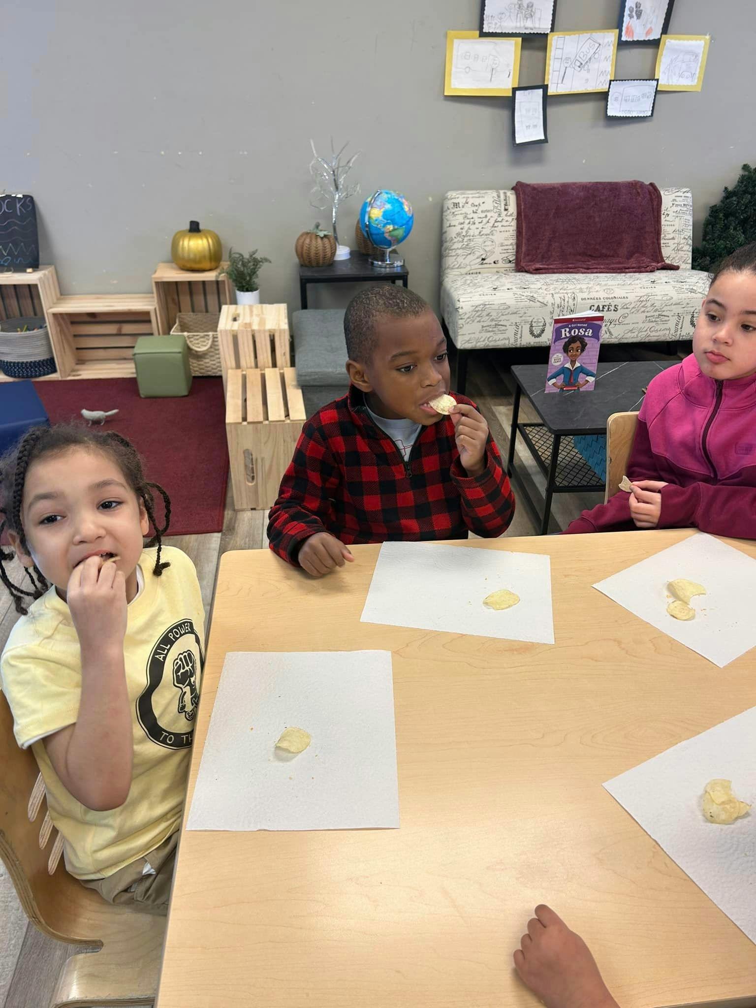 Three children eating snacks at a table