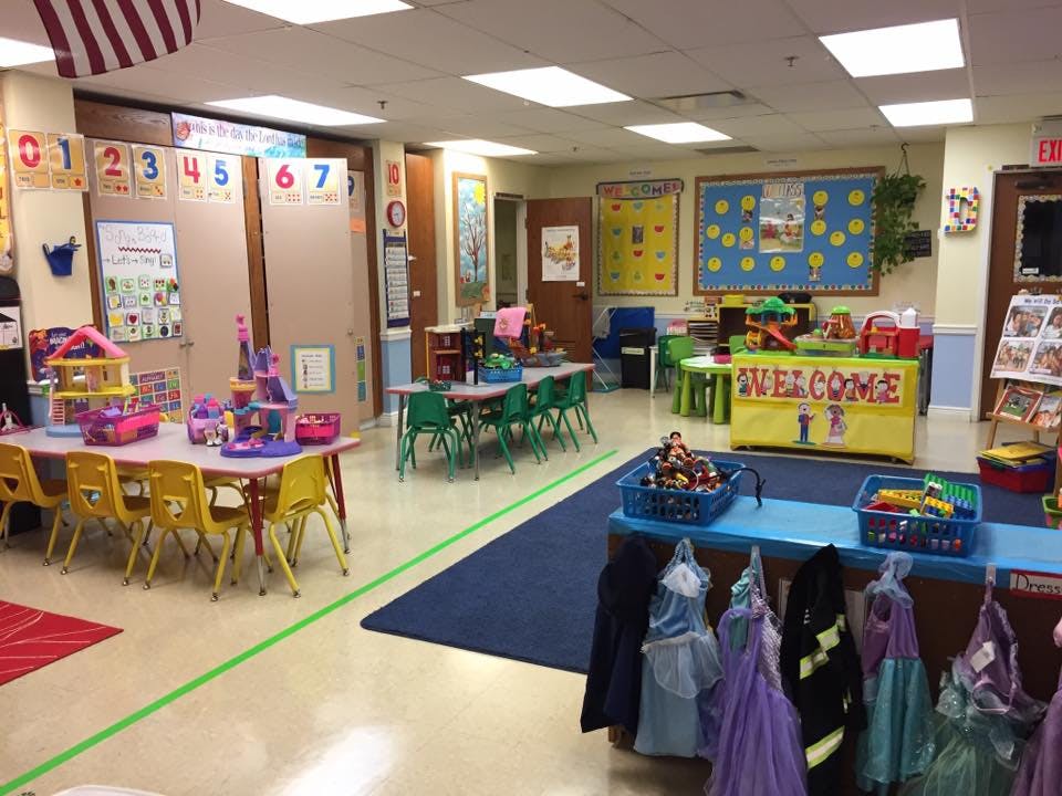 Classroom with small tables and chairs, toys, and colorful decorations