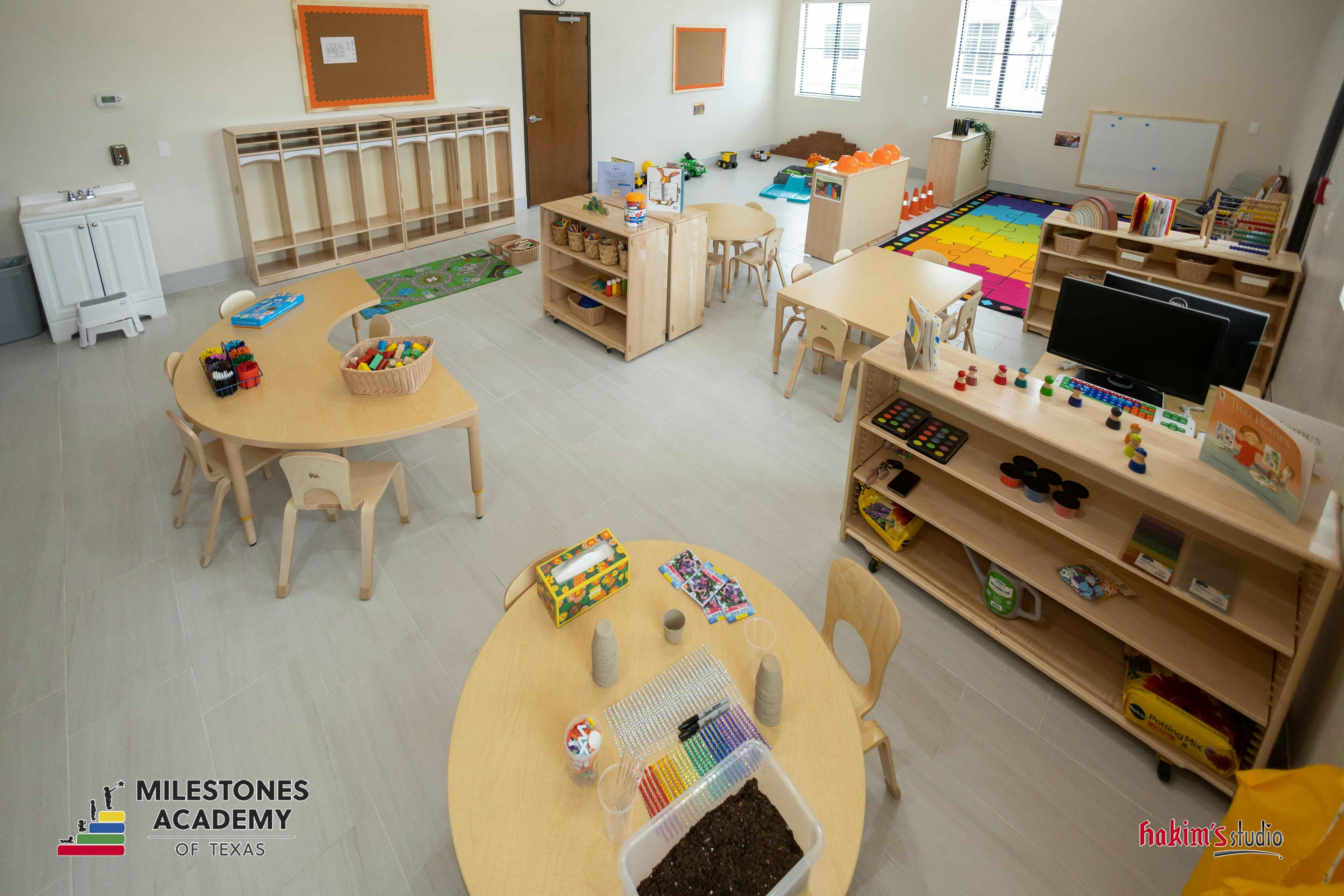 Classroom with multiple activity stations, tables, and cubbies