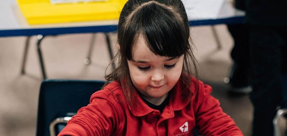 Child in red shirt looking down
