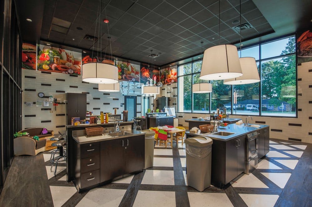 Large room with multiple kitchen islands and large windows