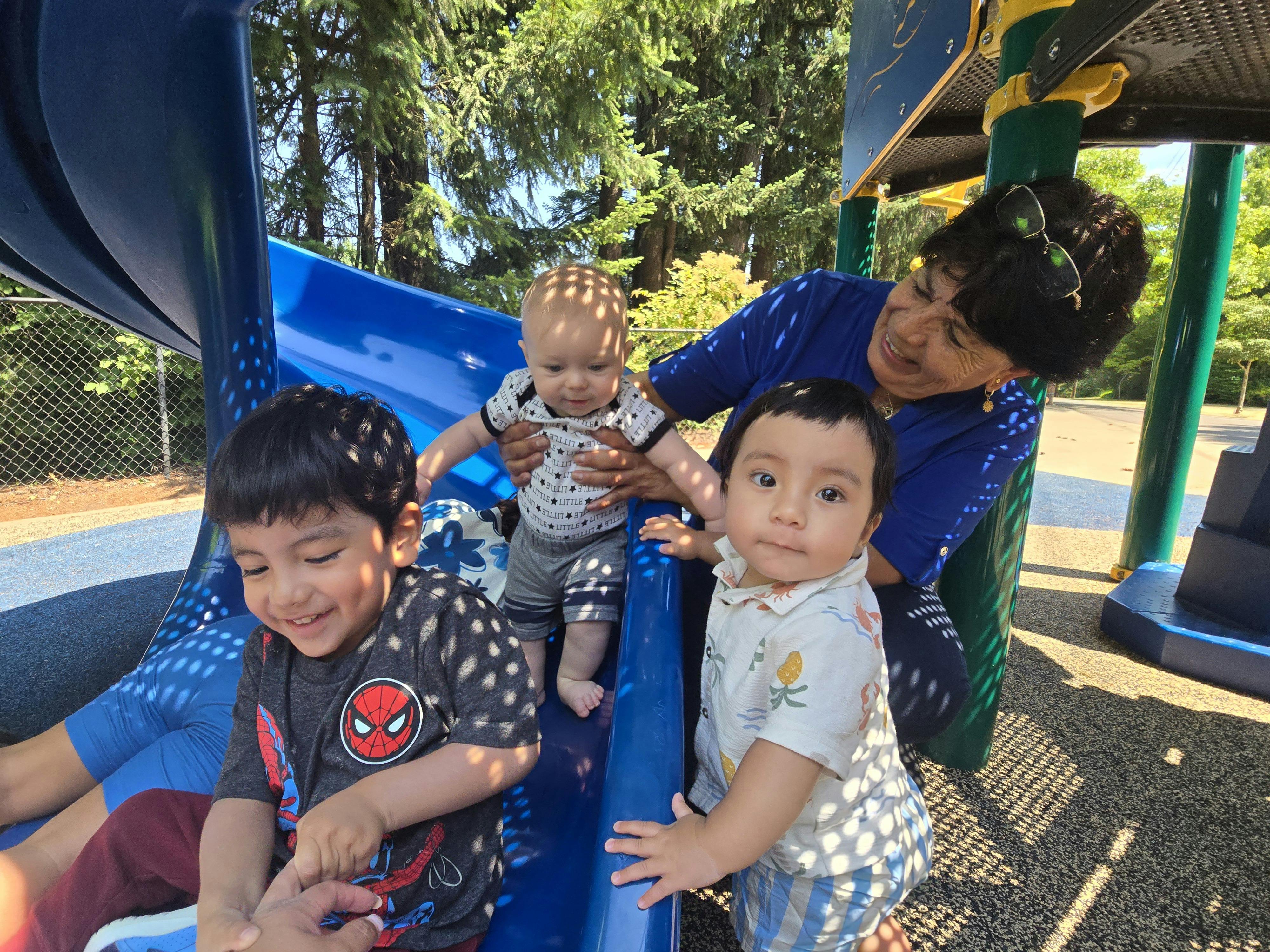Adult and three children on a playground slide