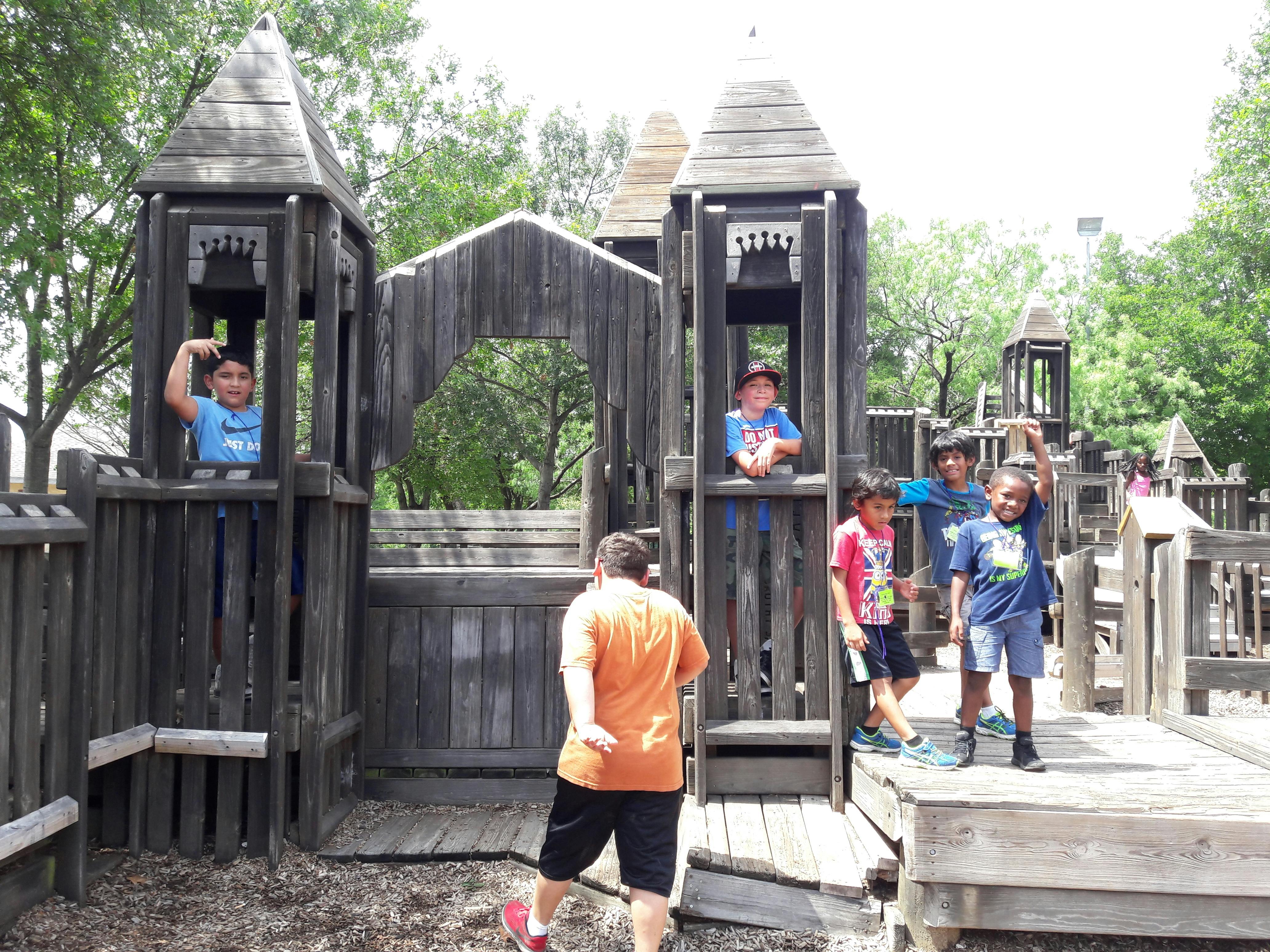 Children playing on a wooden playground structure