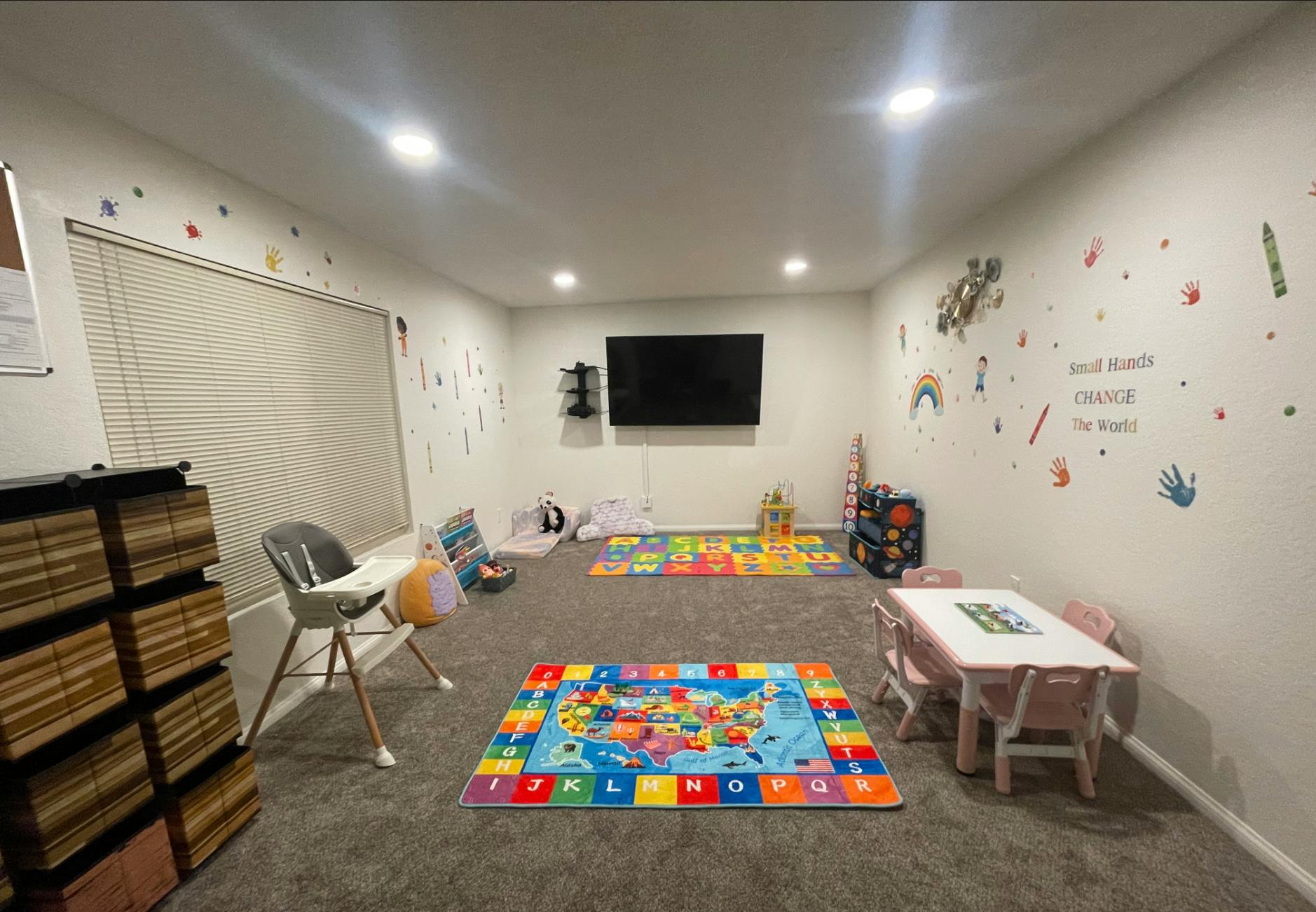 Playroom with colorful alphabet mats, small table and chairs, and wall decals