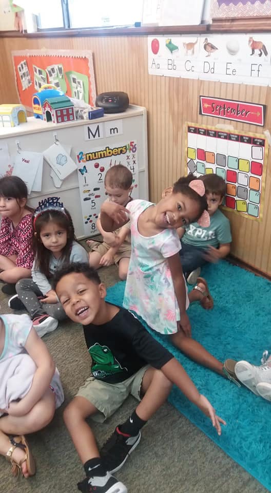 Children sitting on the floor in a classroom