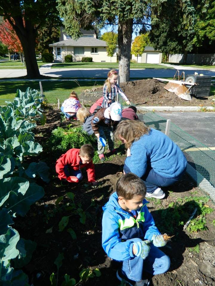 Adults and children gardening in a community garden