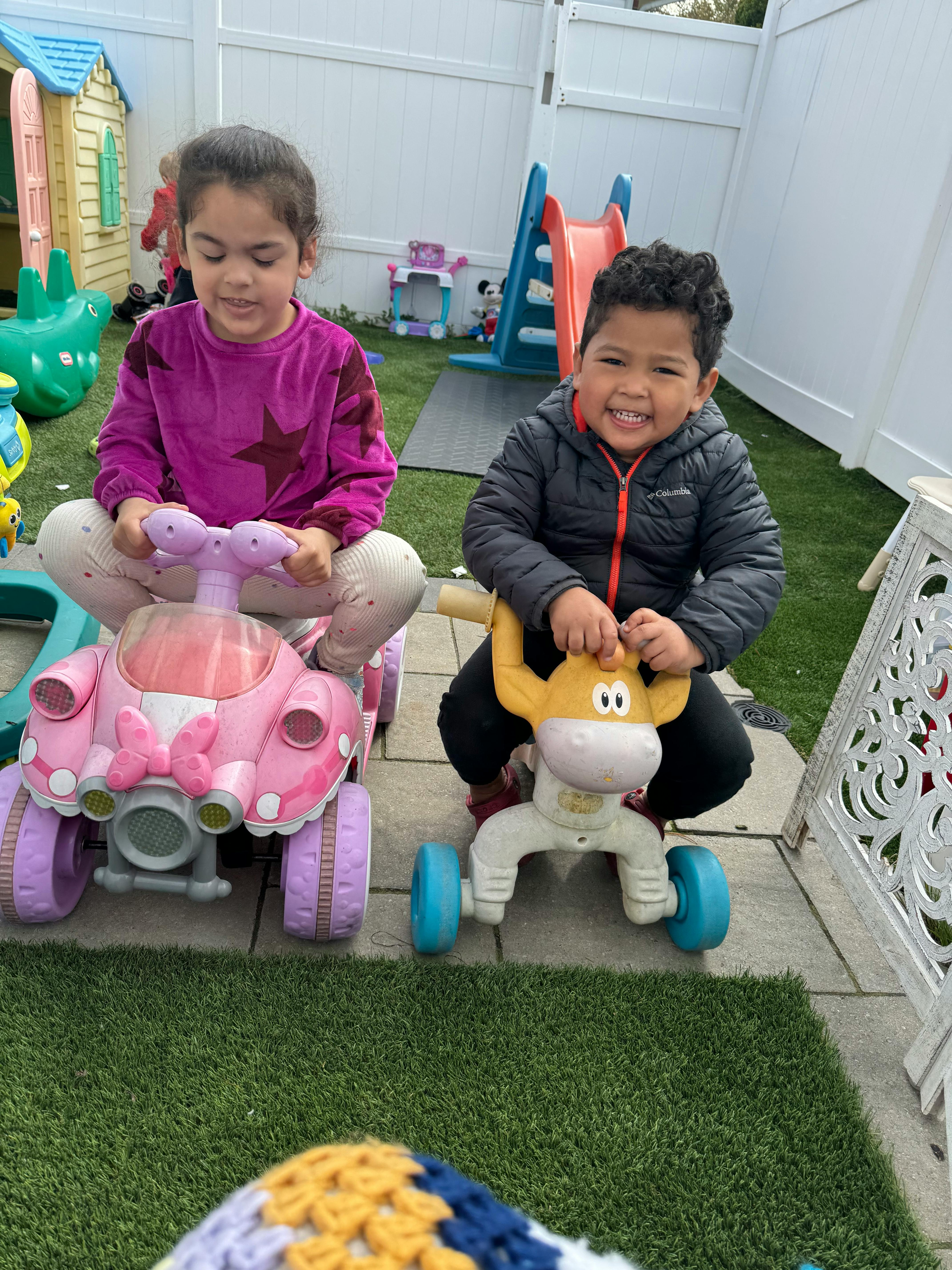 Two children on ride-on toys outdoors