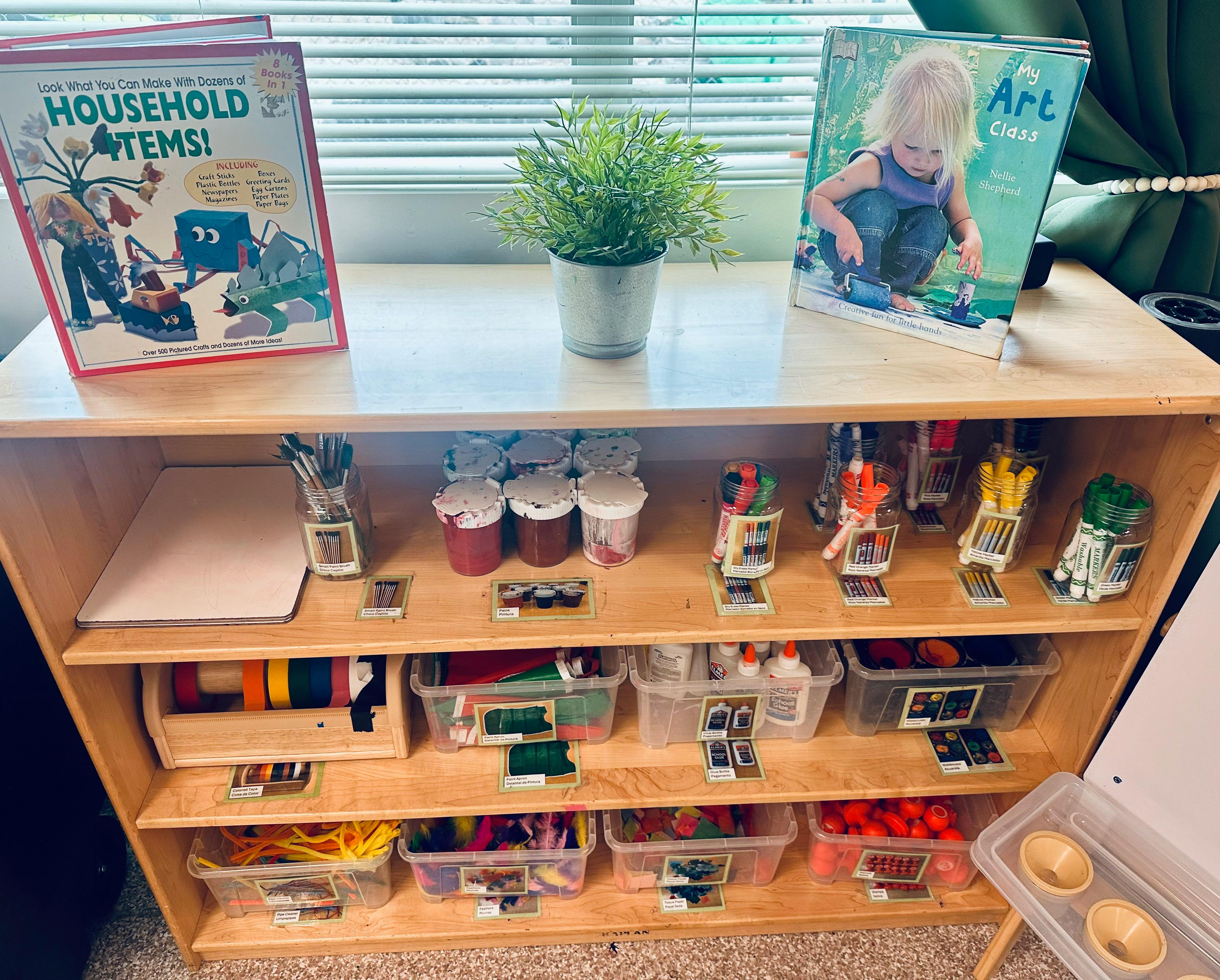 Books and art supplies on a wooden shelf