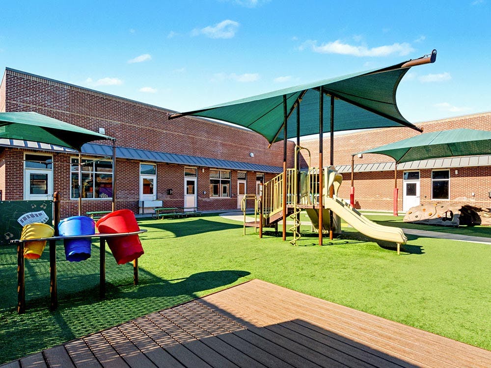 Outdoor children's playground with shade coverings, slide, and musical toy