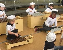 Children in sailor hats playing xylophones