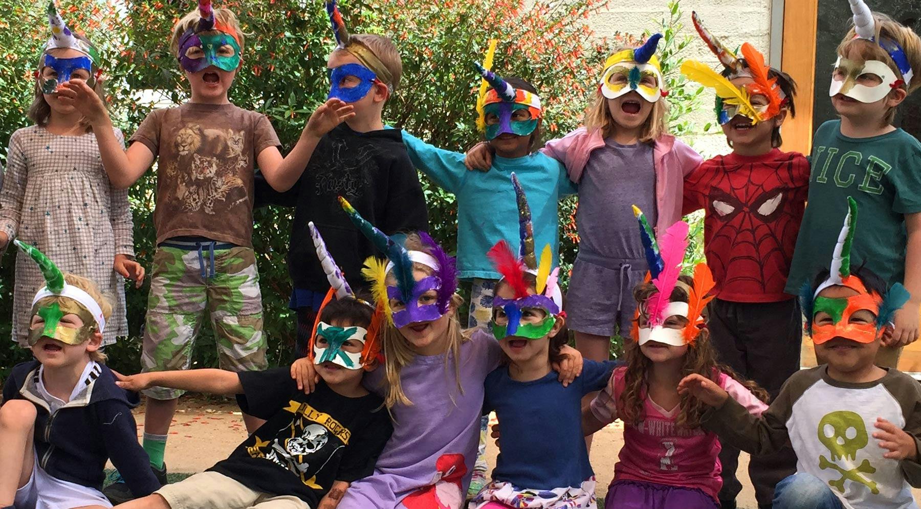 Group of children wearing handmade unicorn masks outdoors