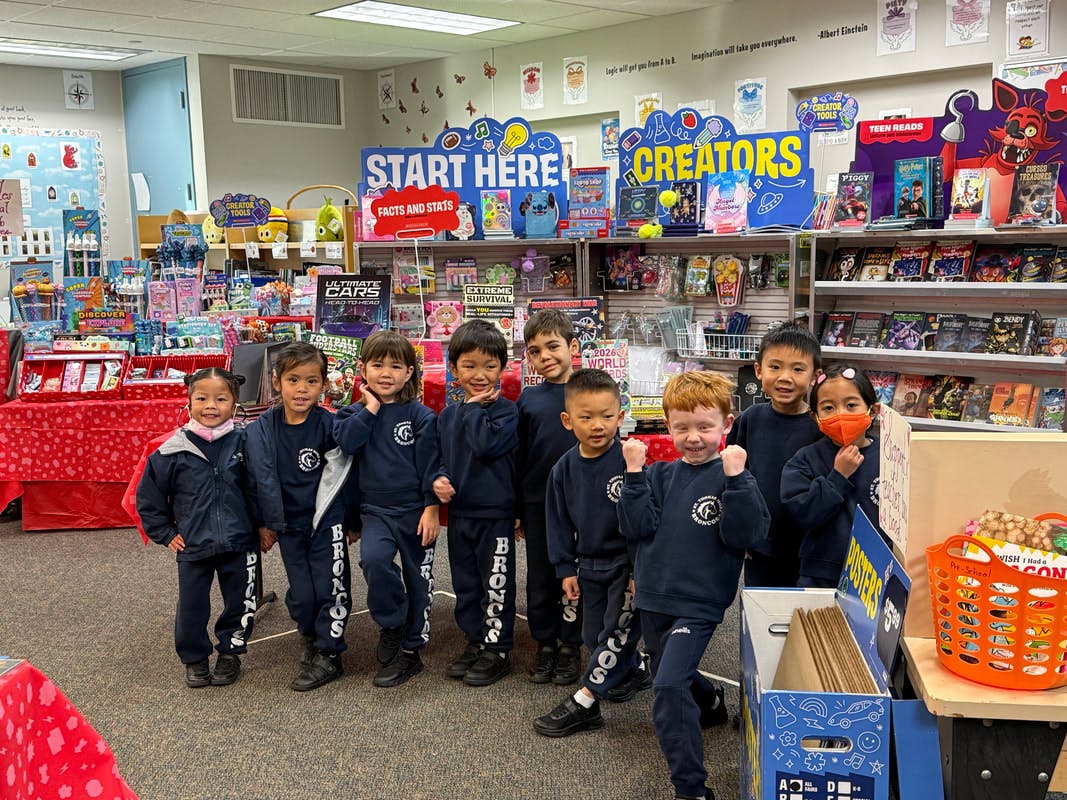 Group of children standing in front of a colorful display in a school store