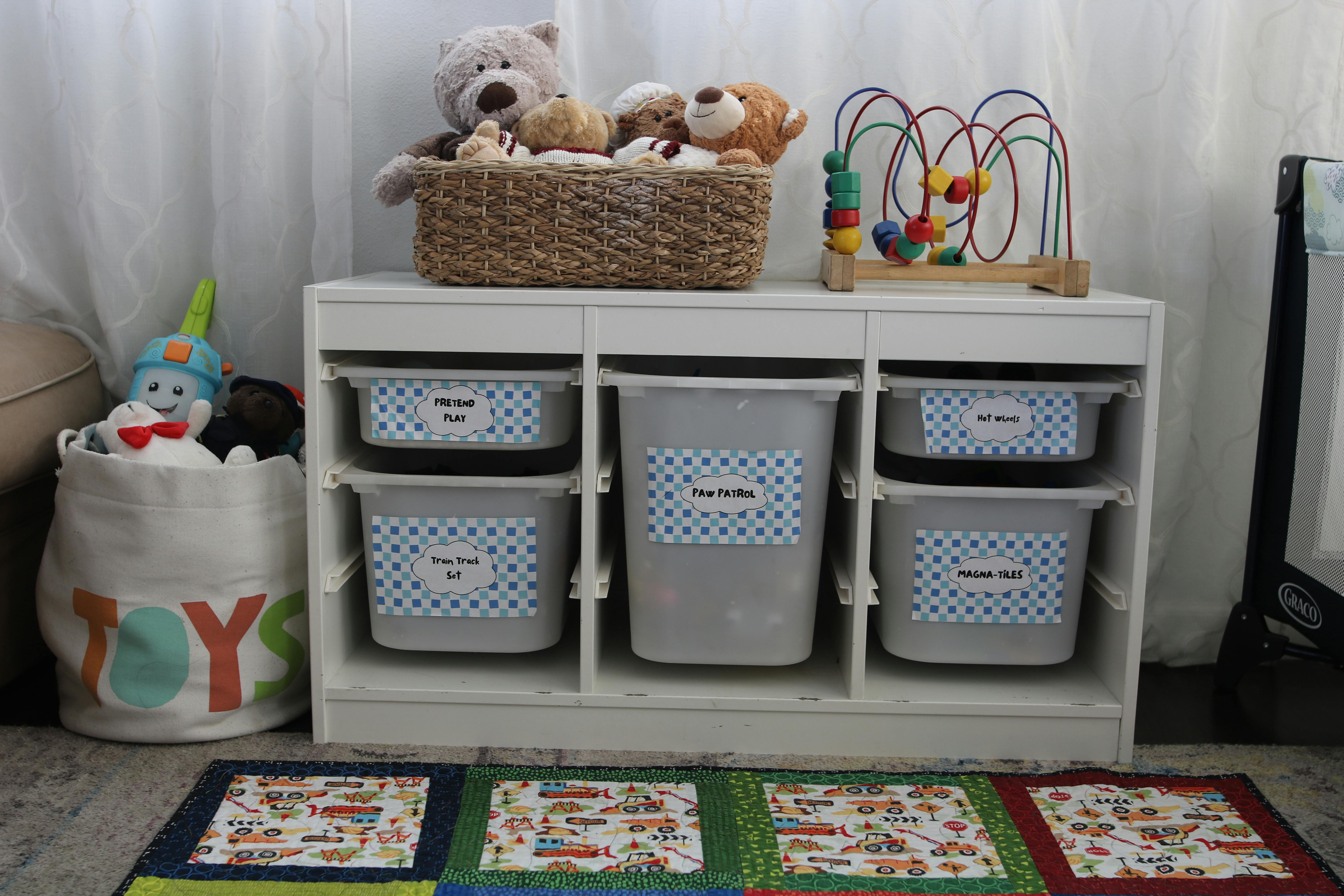 Toy storage unit with bins, a basket of stuffed animals, and a bead maze