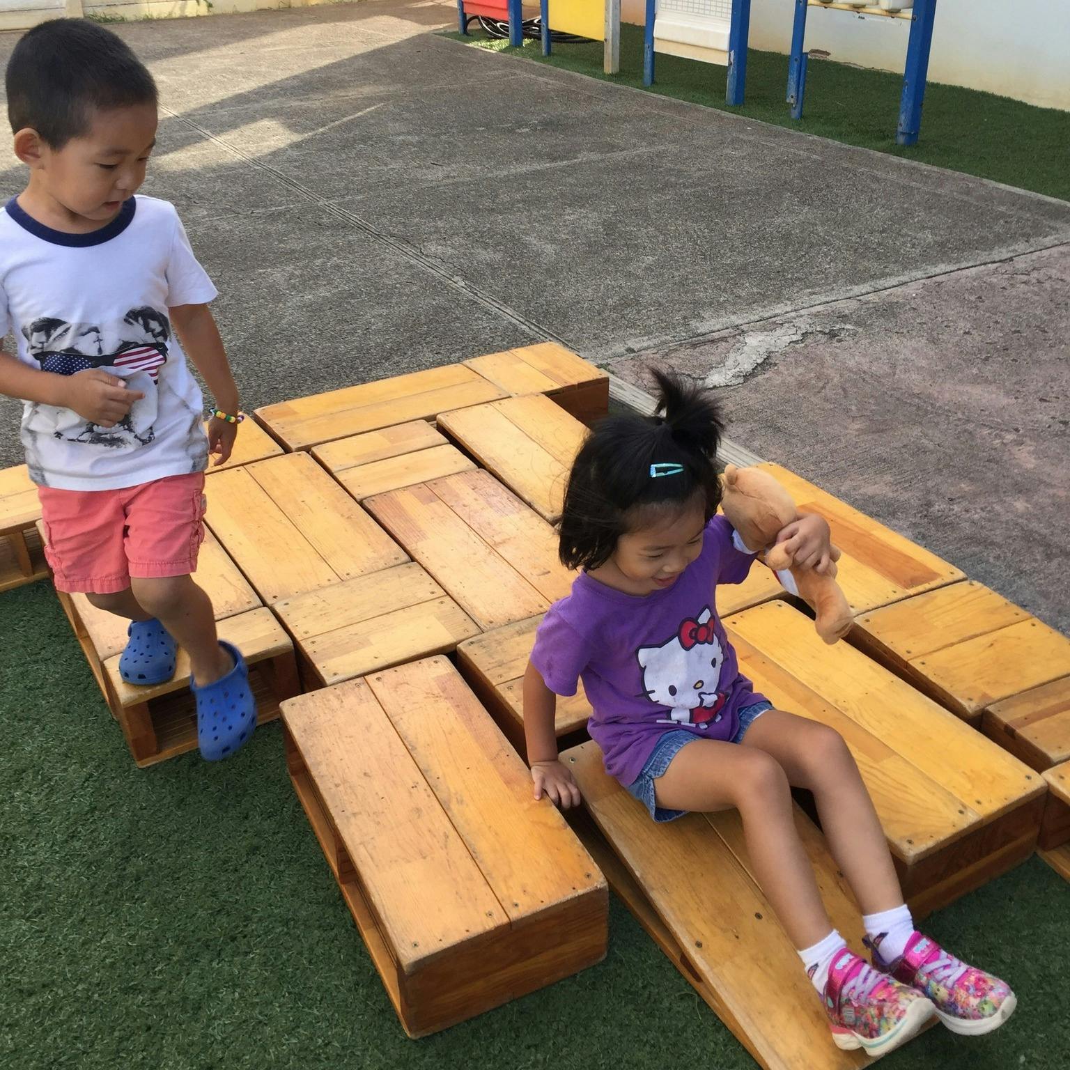 Two children playing on wooden blocks