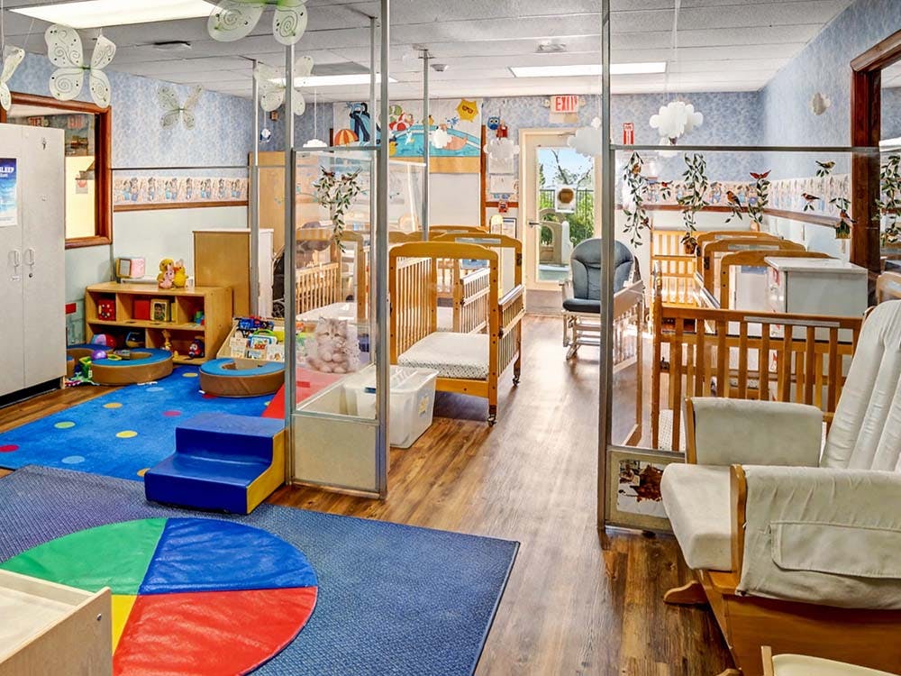 Cribs and play area in a daycare classroom