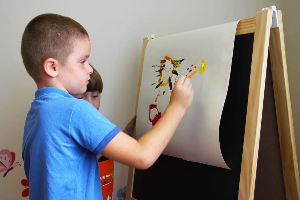 Child painting on an easel