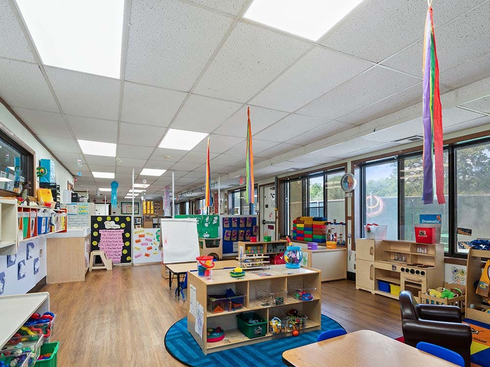Empty colorful preschool classroom with play kitchen and toys