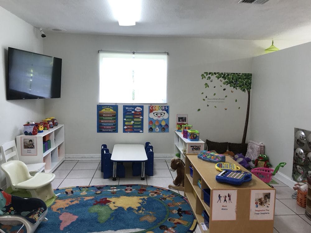 Playroom with a world map rug, small table and chairs, and shelves with toys