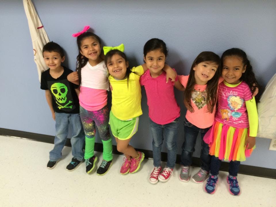 Six children standing together, some with arms around each other