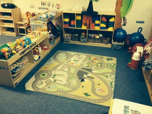 Playroom with a road map rug and shelves of toys
