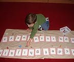 Child playing with alphabet cards on the floor