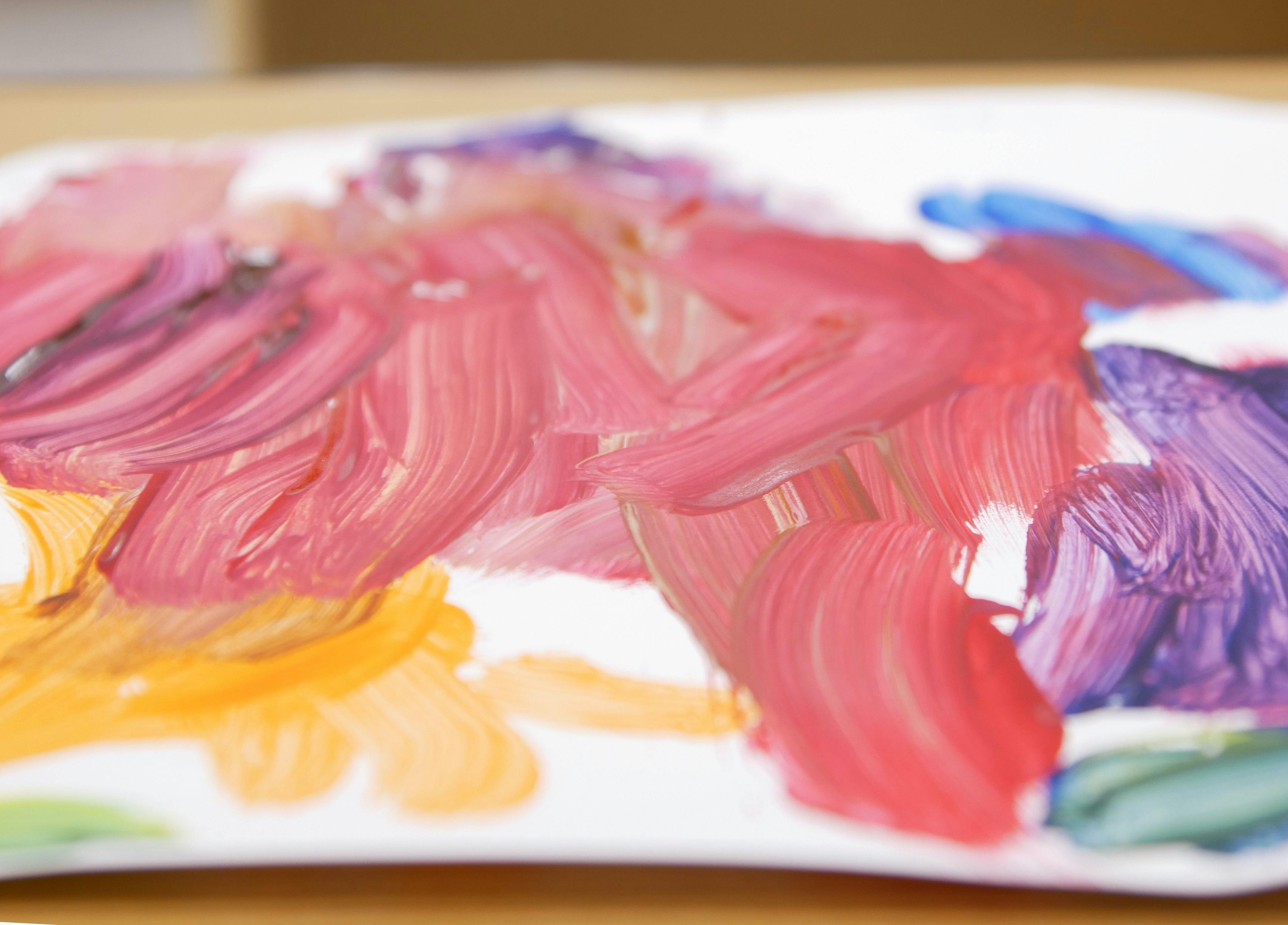 Colorful paint strokes on a white surface