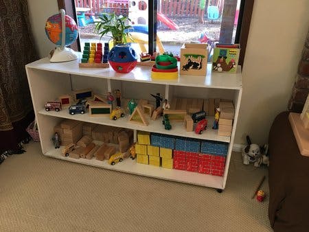 White shelving unit with various toys and a globe