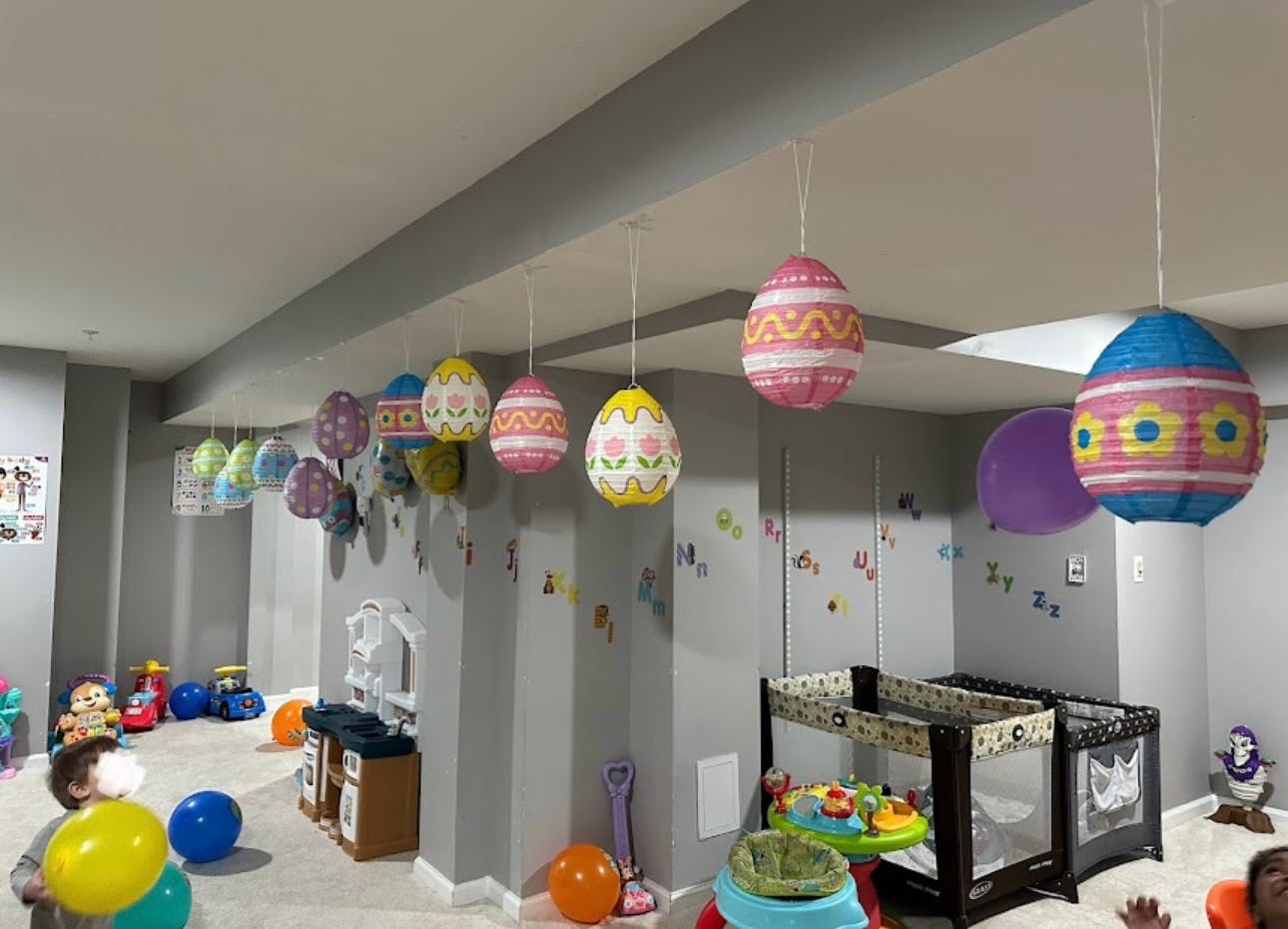 Playroom with hanging egg decorations and playpens