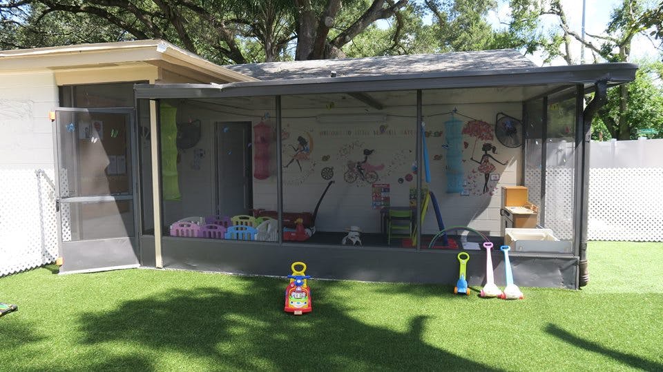 Screened-in porch with toys on artificial grass
