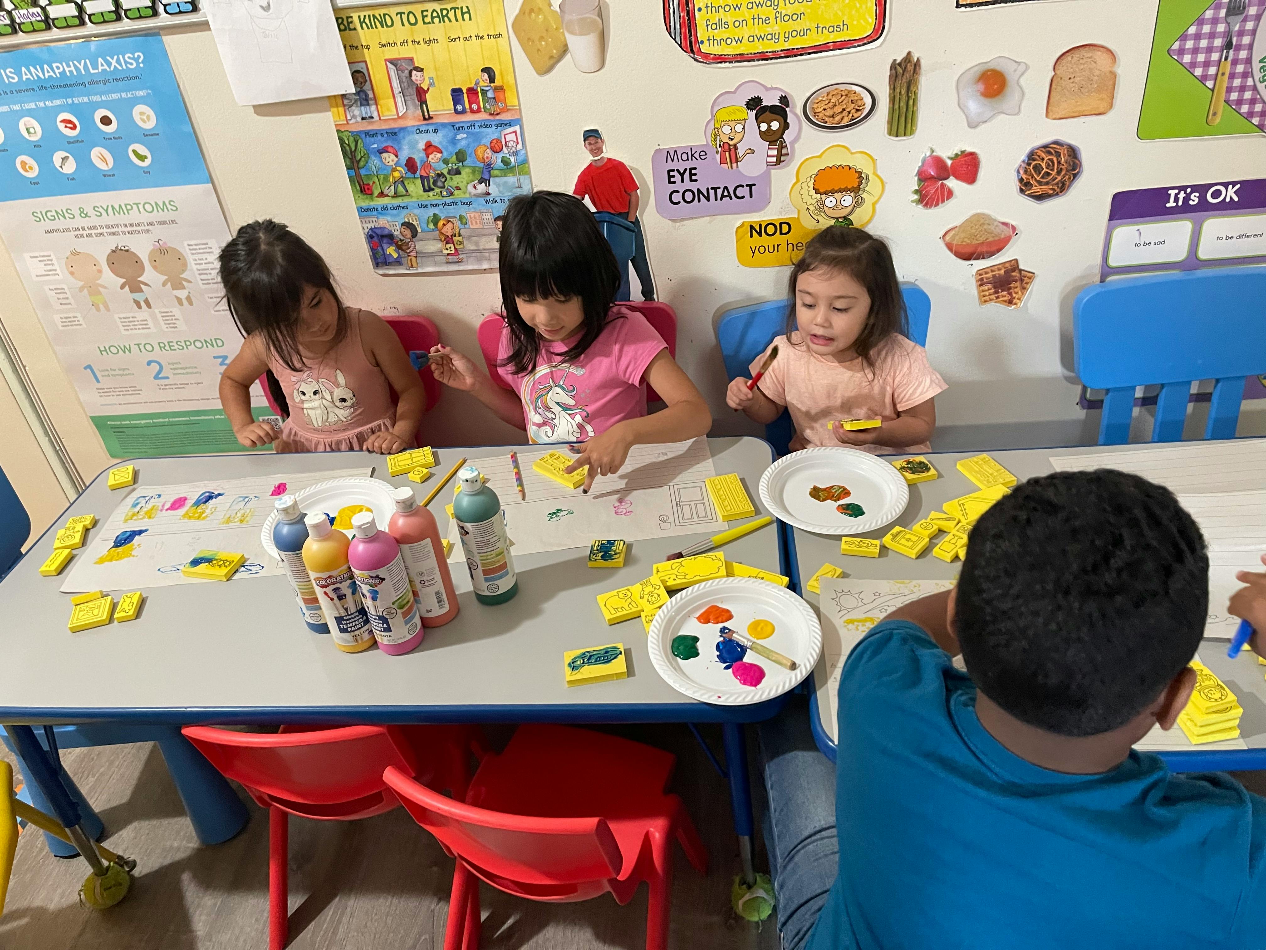 Children painting at a table in a classroom