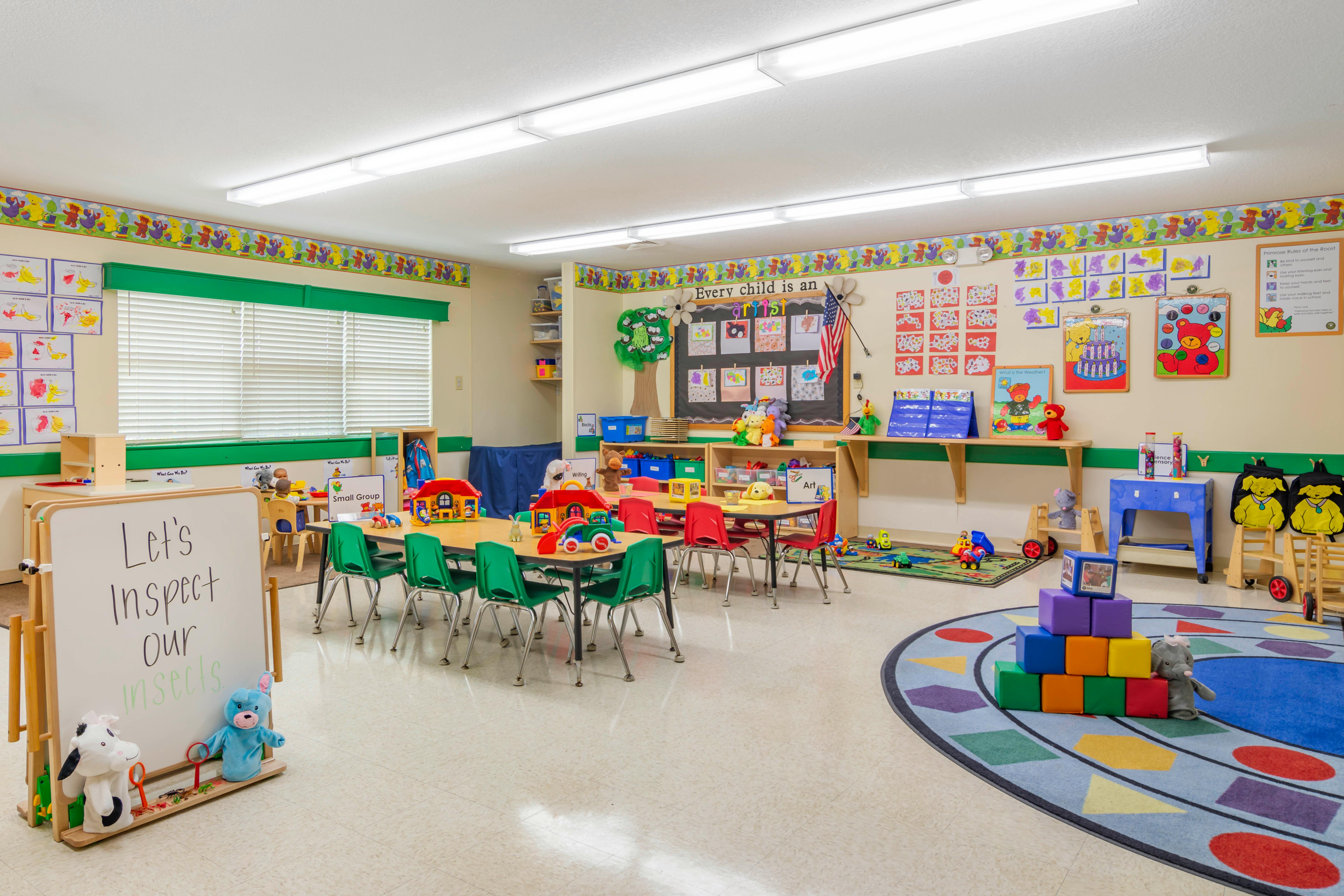 Classroom with small tables and chairs, toys, and learning materials