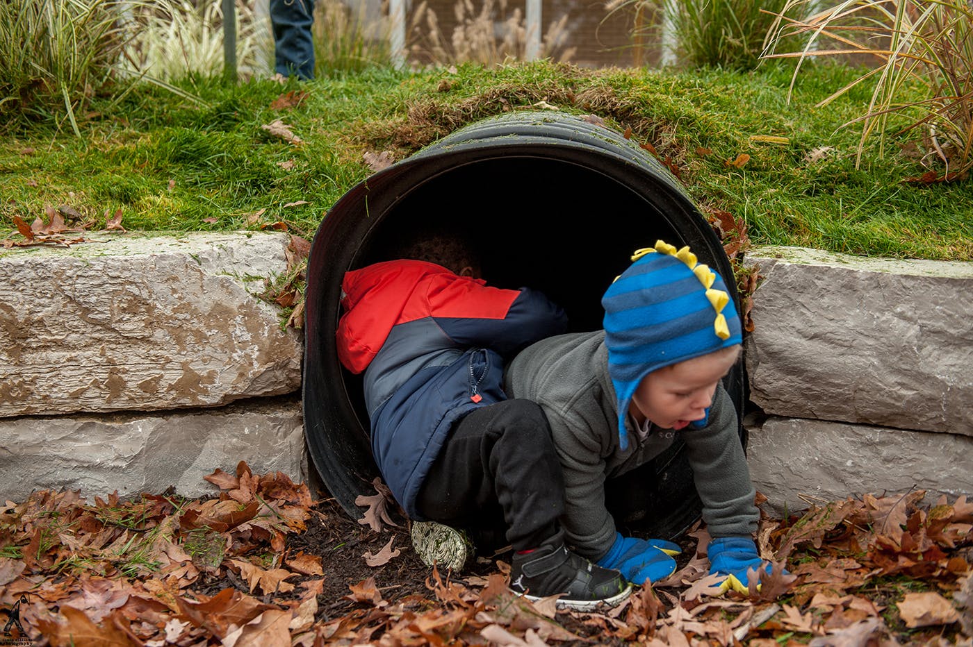 Two children crawling through a dark tunnel