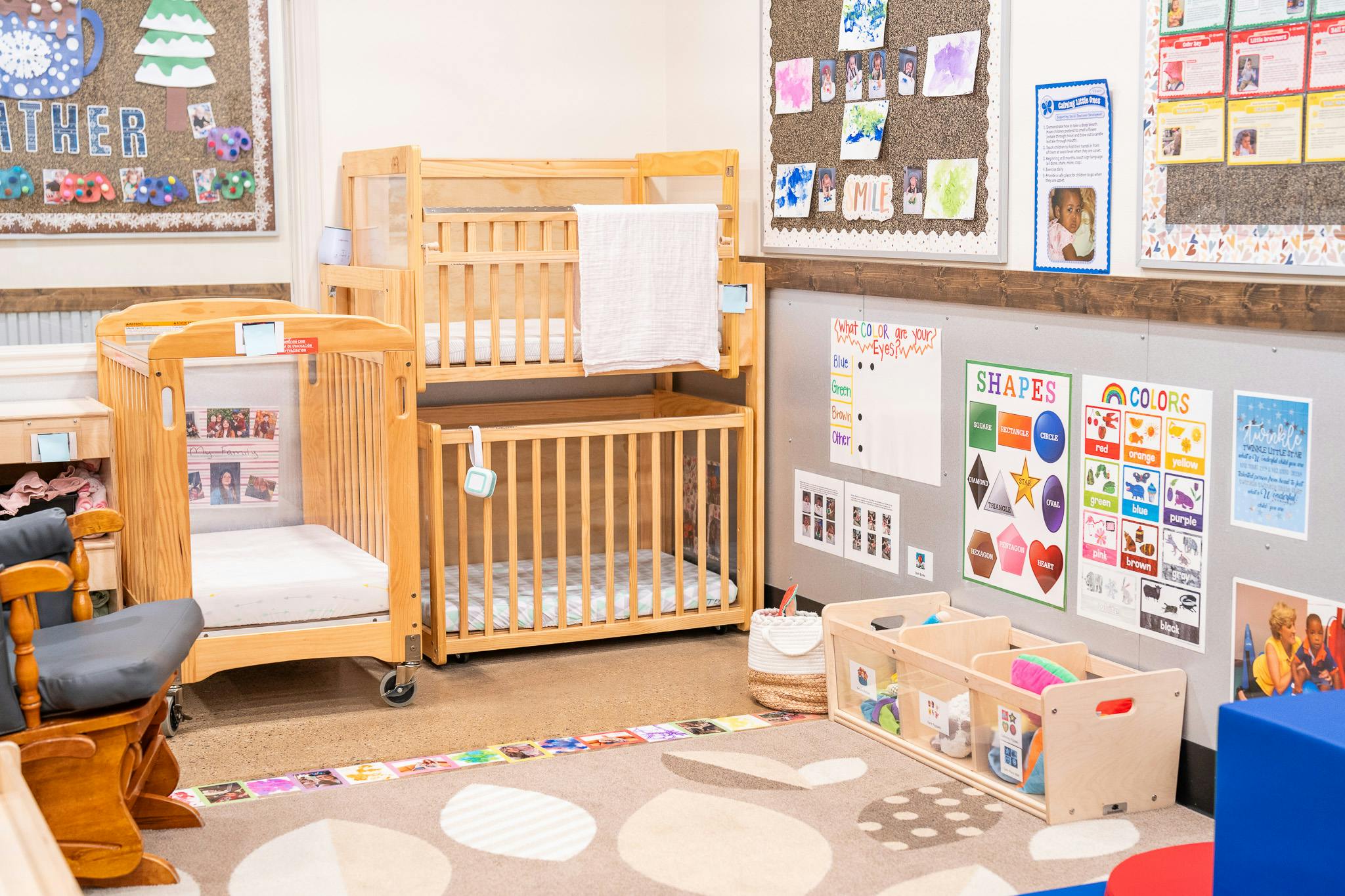 Wooden cribs and child care educational posters in a daycare classroom