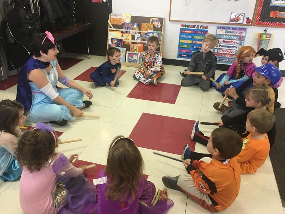 Adult and children sitting in a circle on the floor