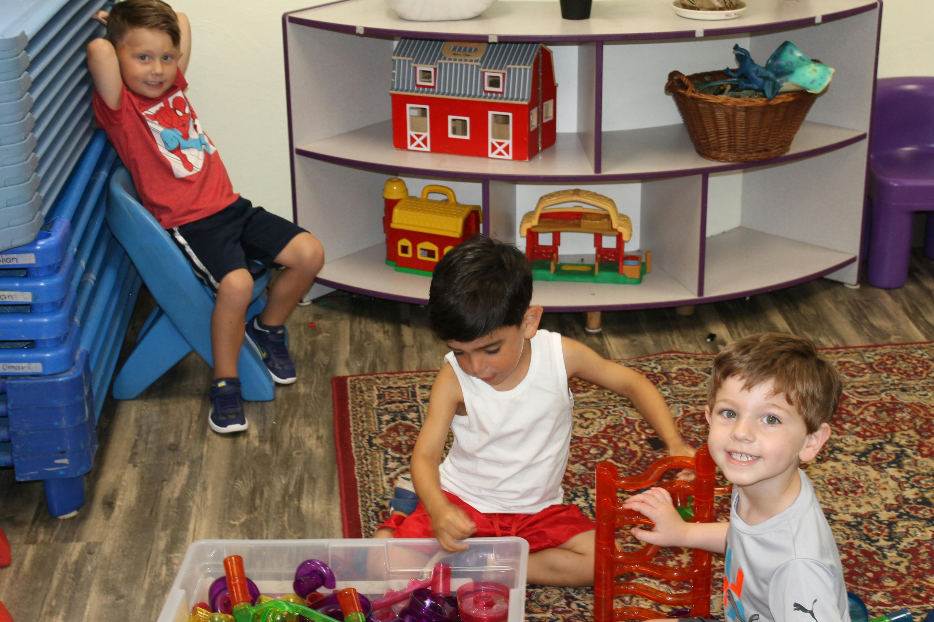 Three children playing with toys in a room