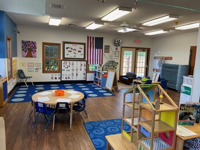 Round table with blue chairs in a classroom with a US flag