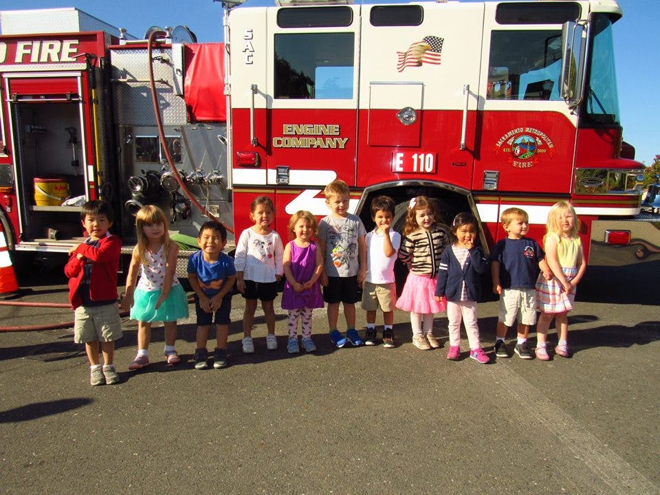 Children standing in front of a fire truck