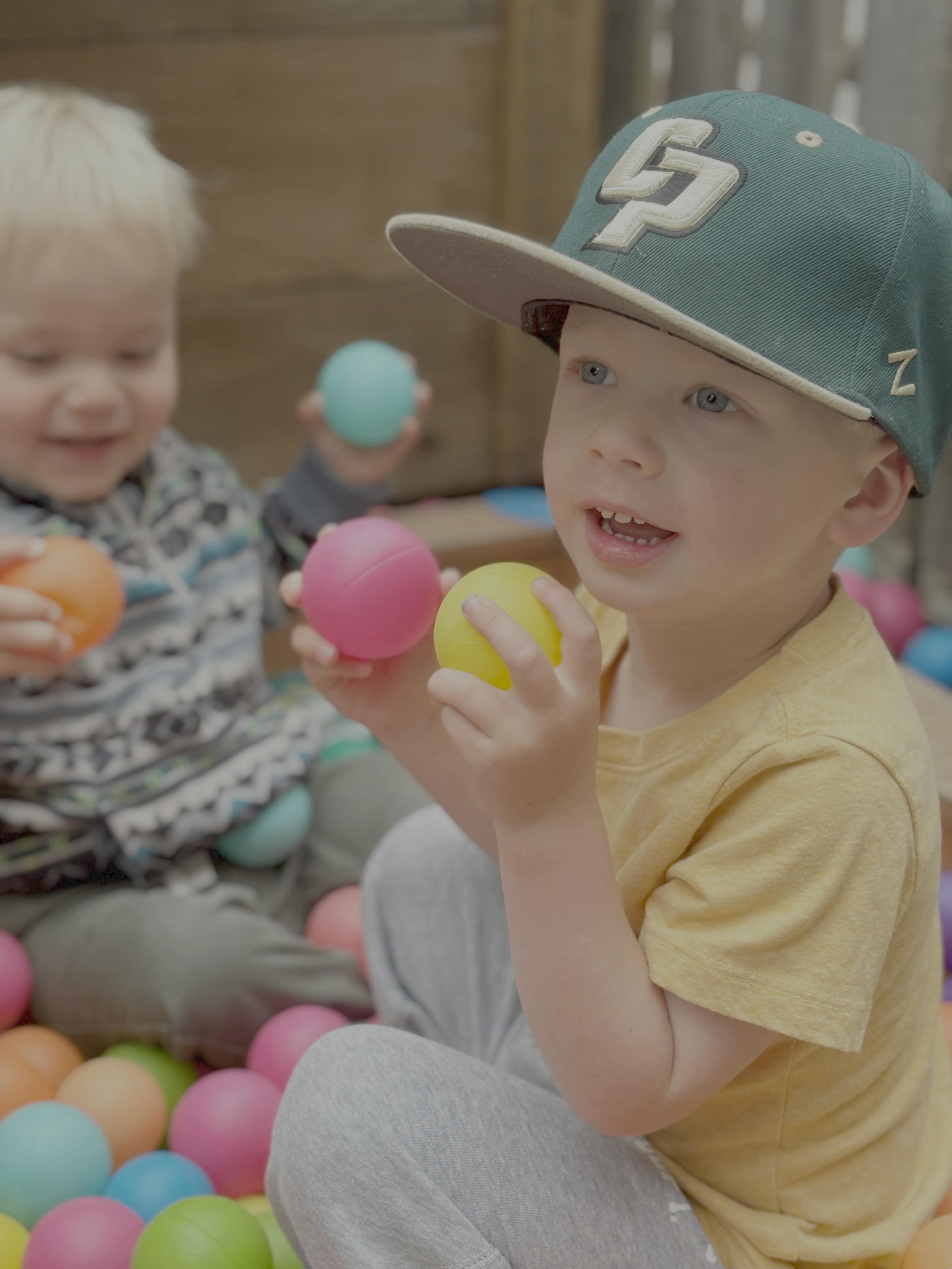 Two children playing in a ball pit