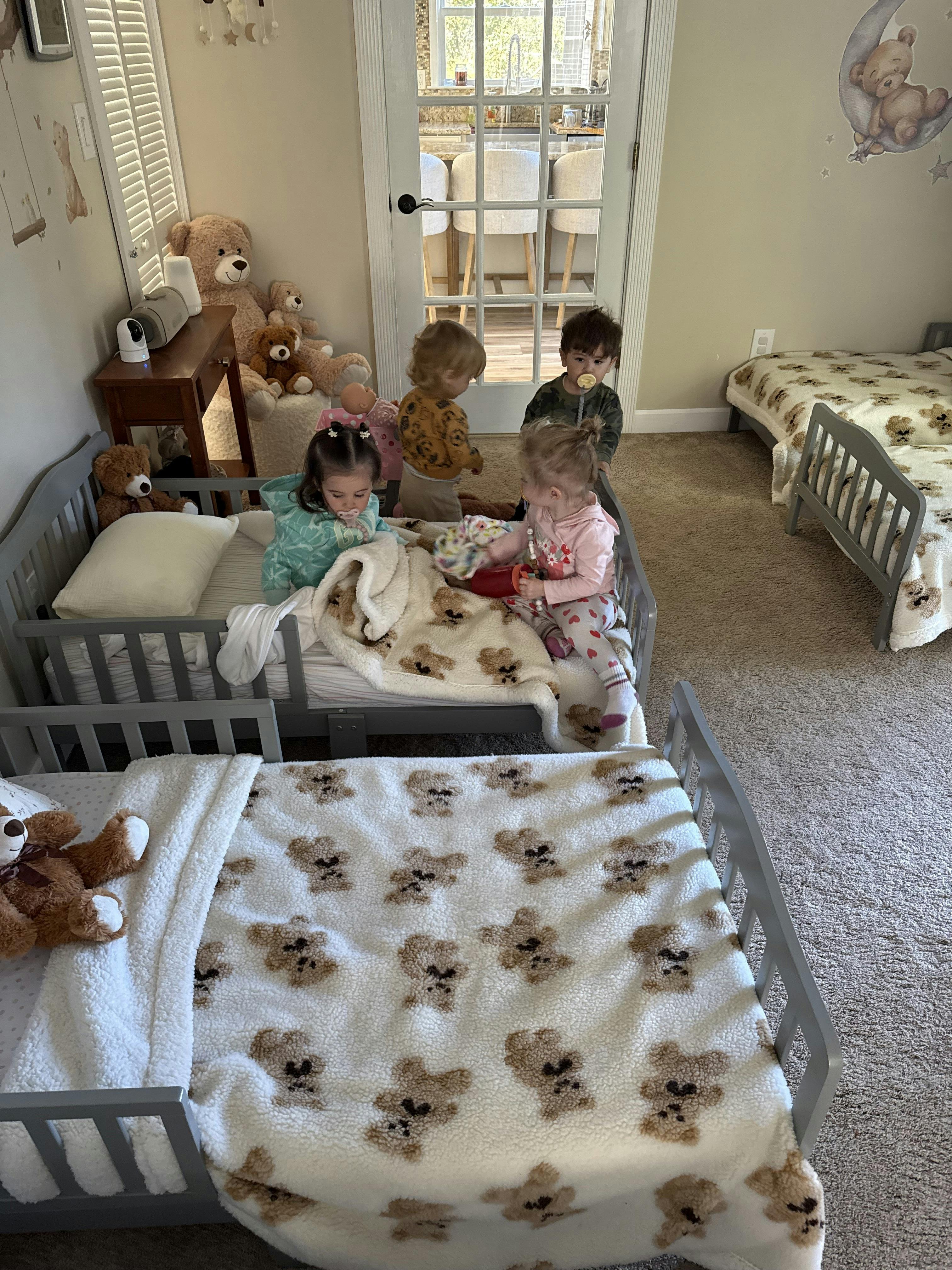 Children playing in a room with small beds