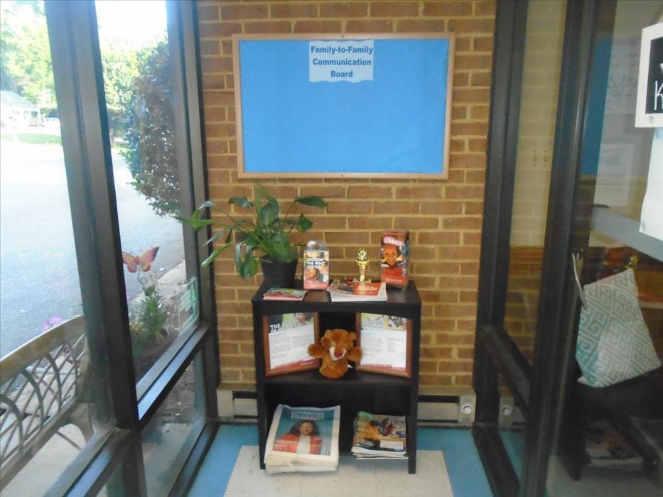 A blue bulletin board with Family-to-Family Communication Board text above a display shelf
