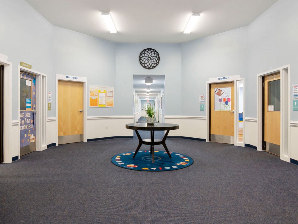 Hallway in a childcare center with doors labeled "Restroom," "Infant 1," and "Toddler 1"