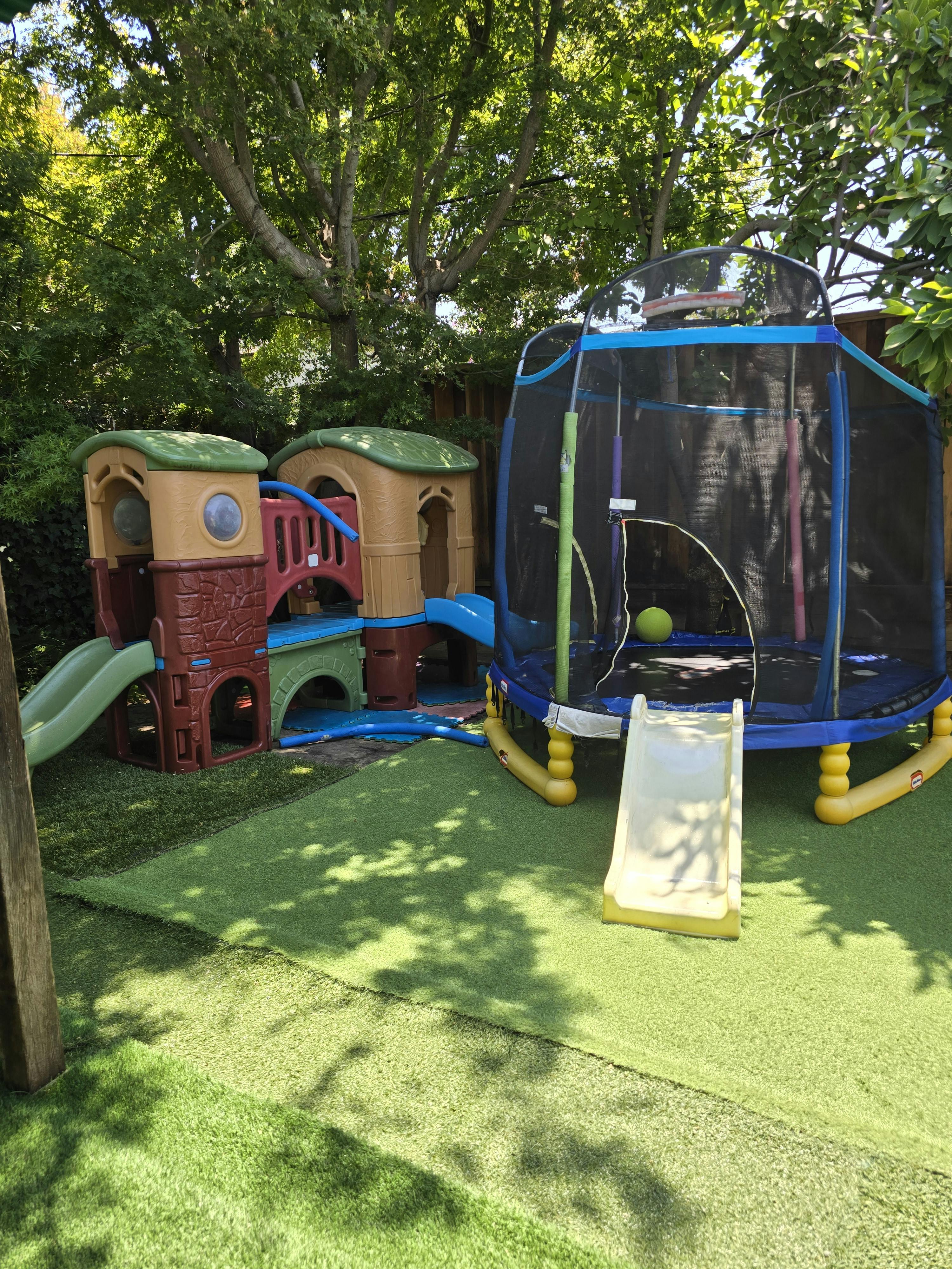 Outdoor playground with a playhouse and a trampoline