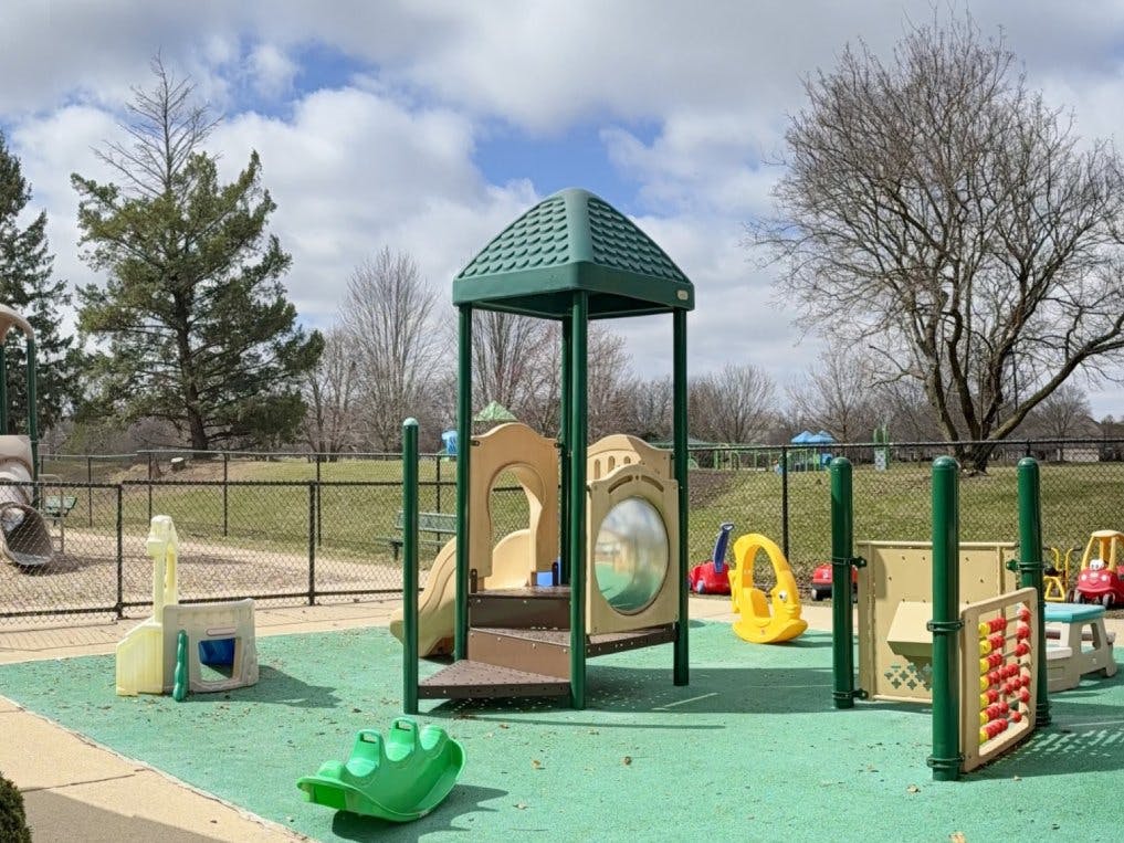 Playground with climbing structure, slide, and smaller play equipment