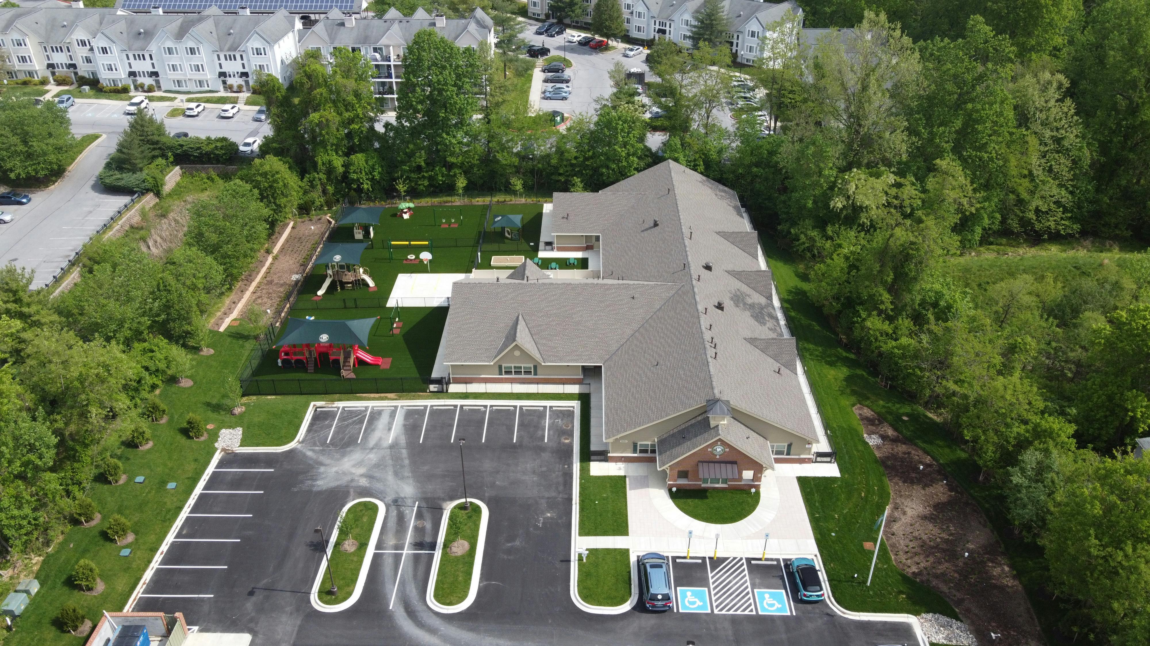 Aerial view of a building with a parking lot and playground