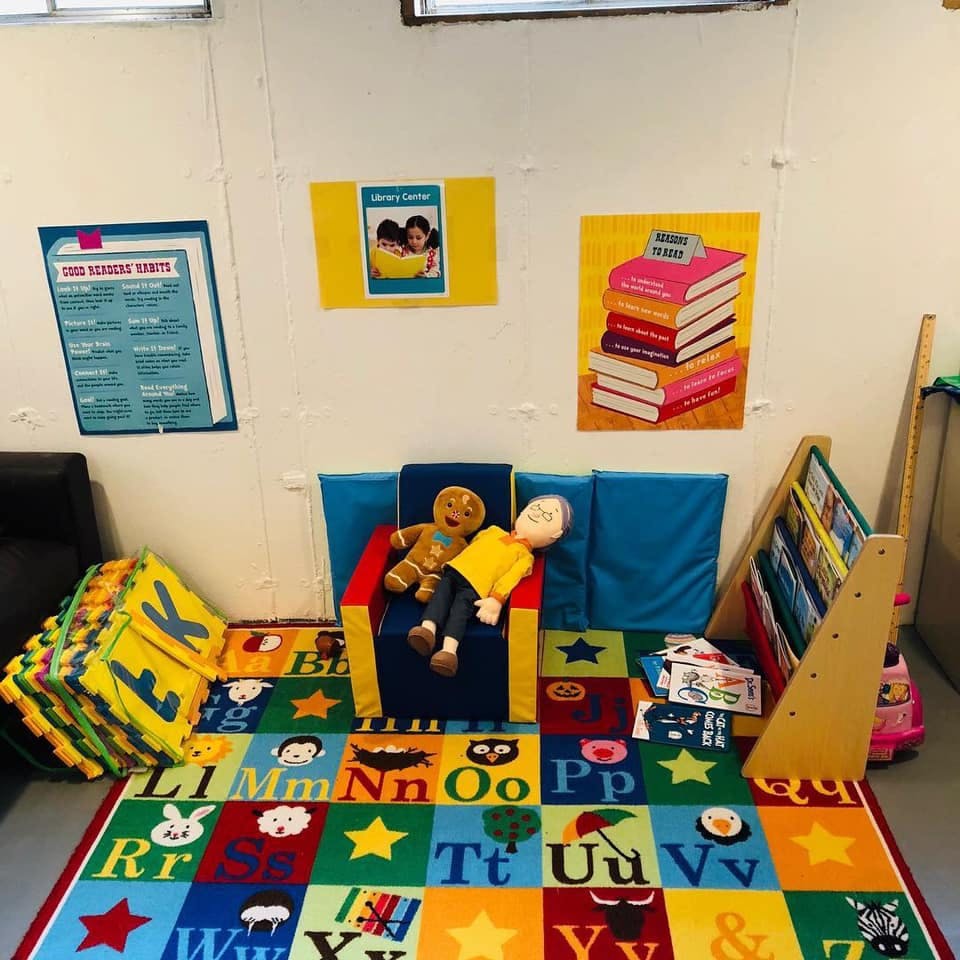 Playroom with alphabet rug, small chair, and stuffed toys