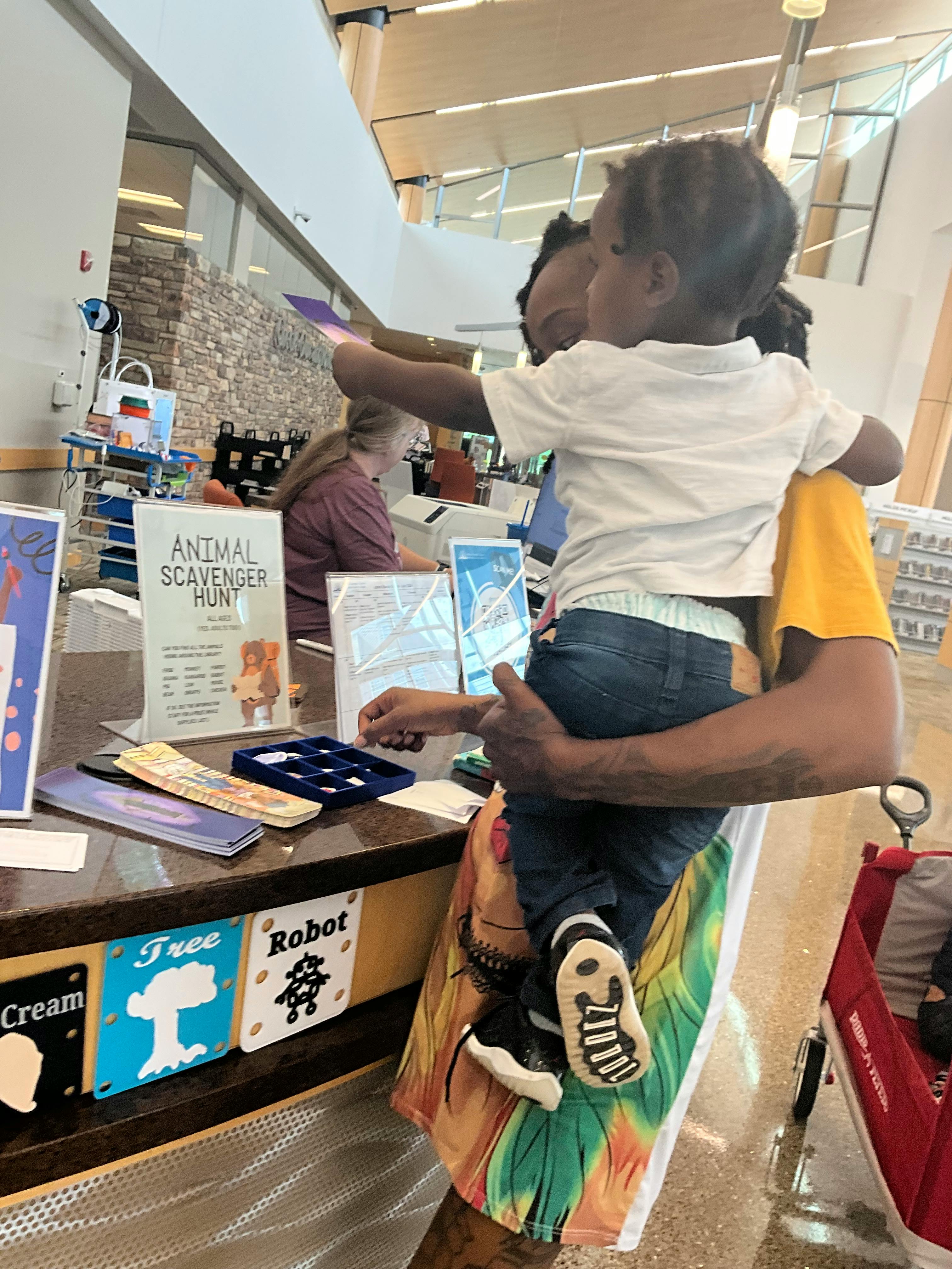 Person holding a child who is reaching for something on a counter