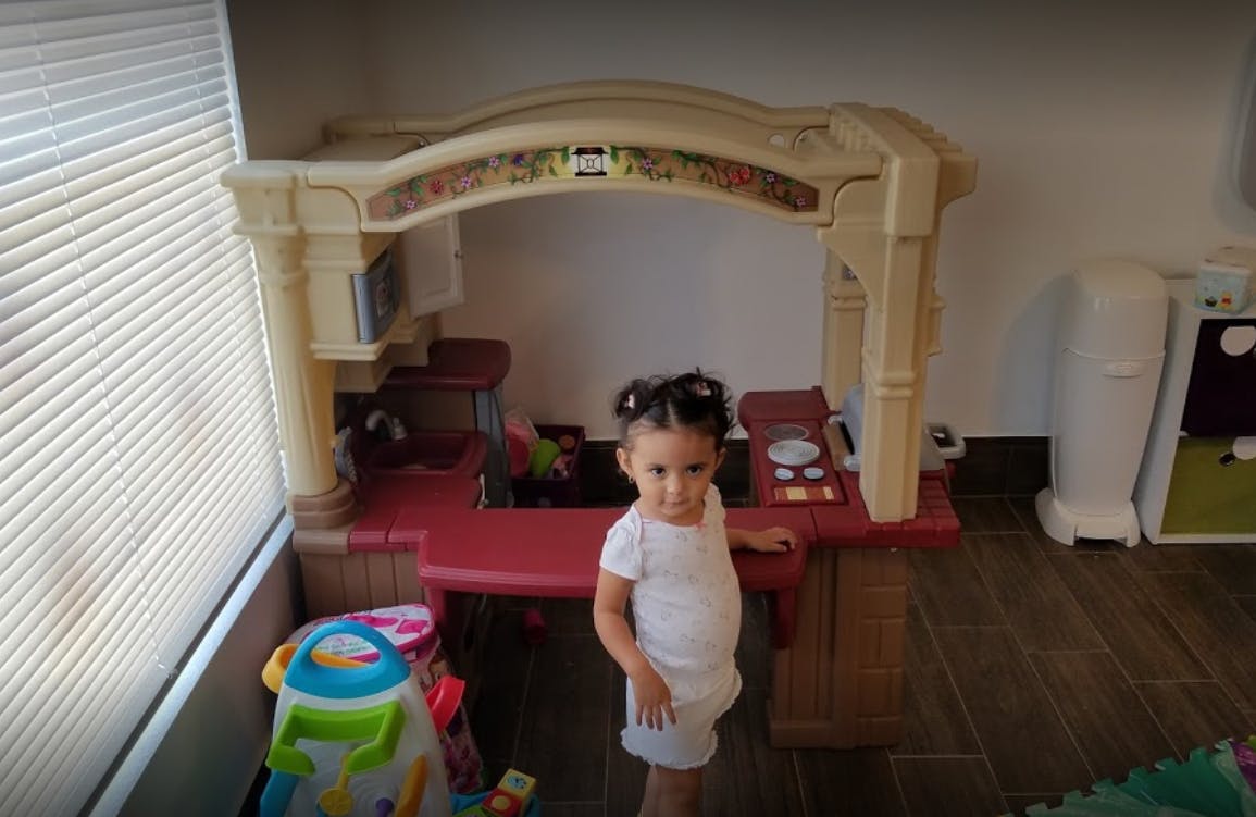 Child standing in front of a play kitchen