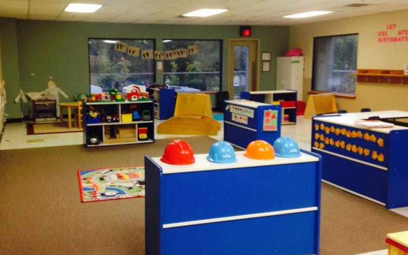 Empty classroom with colorful play furniture and toy construction hats