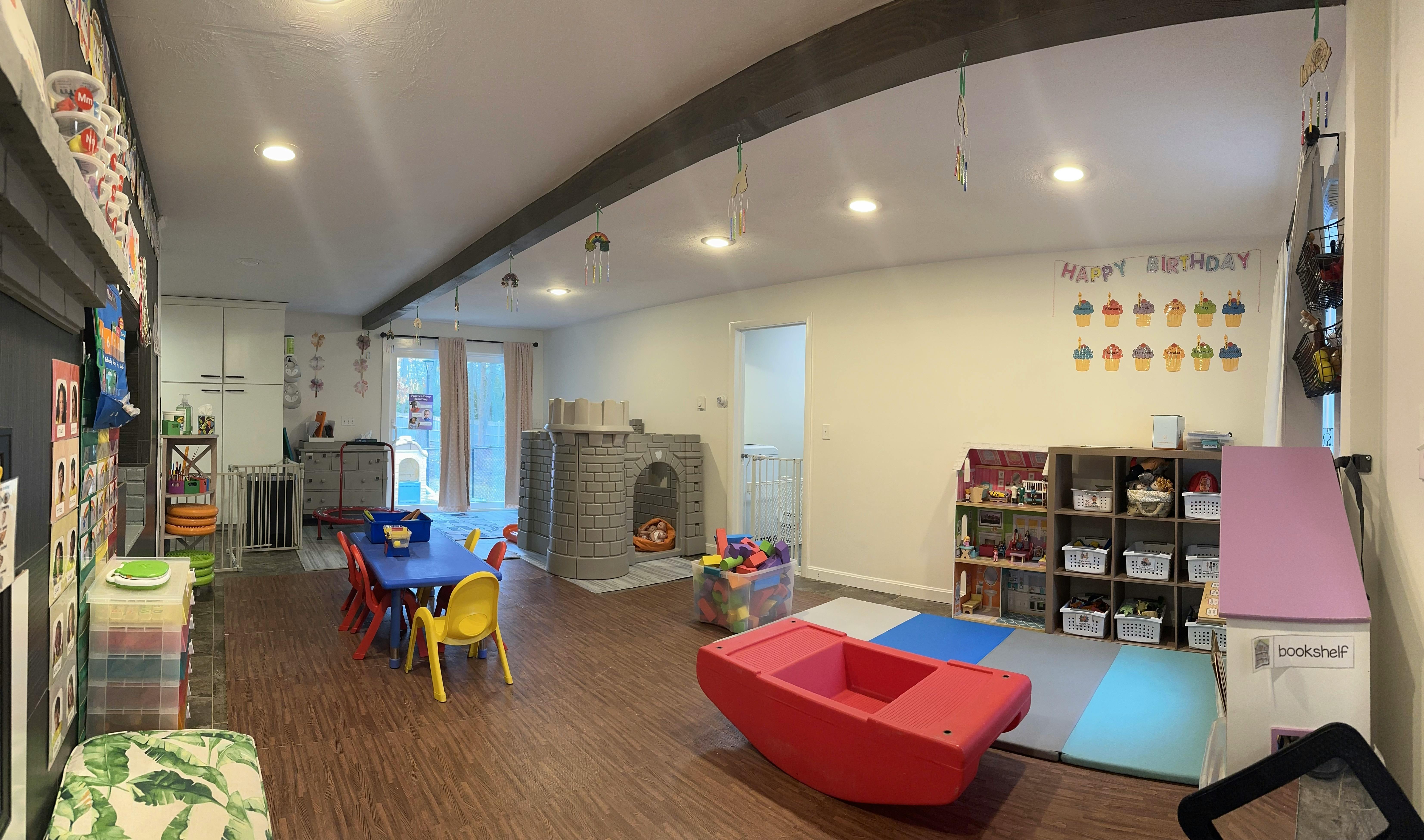 Playroom with small tables and chairs, shelves, and play equipment